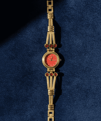 Vintage ladies' gold-tone bracelet watch with ruby-red stones and crimson dial.