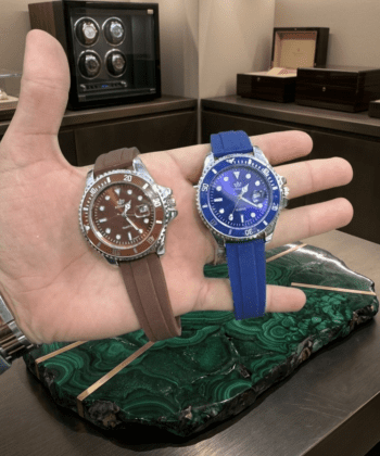 Men's luxury sports watch with blue and brown silicone straps held in hand