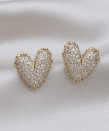 Two pairs of heart-shaped stud earrings, one gold and one silver, fully covered in sparkling crystals.