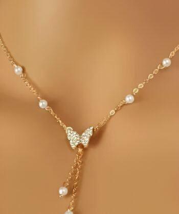 Close up of a golden butterfly choker with pearls and tassel drops on a neck