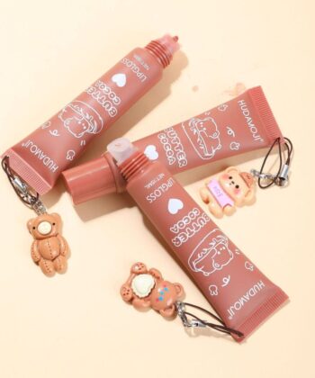 Pack of 2 Huda Moji nude lip glosses with cocoa butter in cute teddy-style packaging for a high-pigment glossy finish.