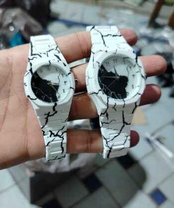 Matching his and hers Tiger Aura watches with white and black marble patterns.