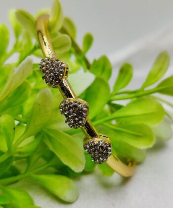 Gold-toned bow and heart adjustable bracelet with crystal embellishments.