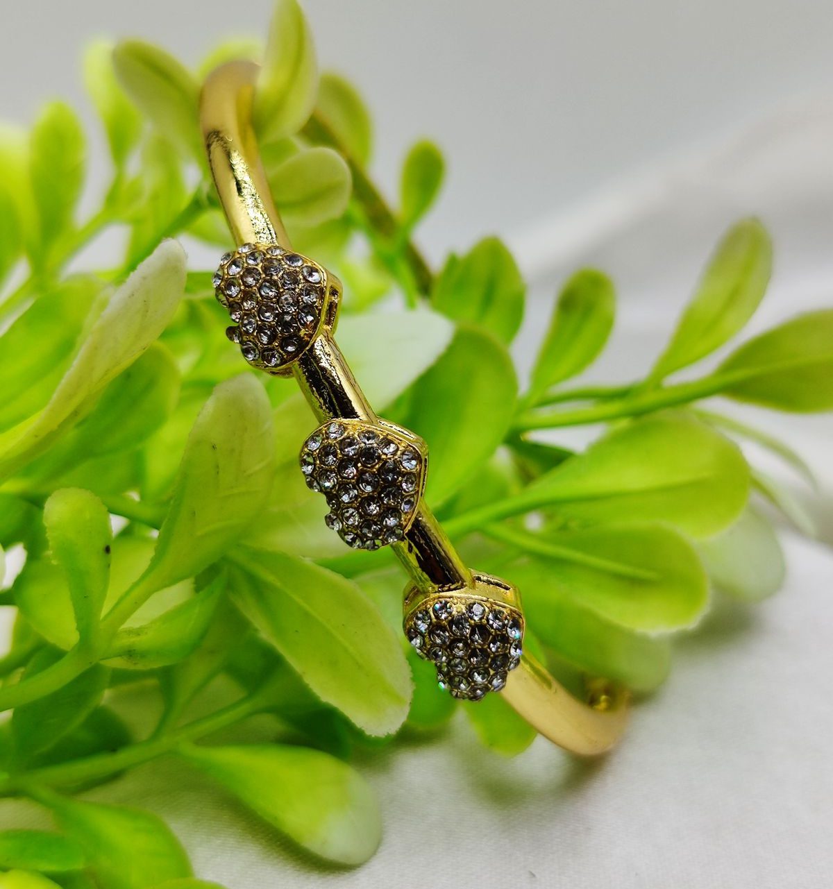 Dazzling Double Heart Bow Bracelet. Gold-toned bow and heart adjustable bracelet with crystal embellishments.