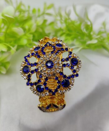 Gold-plated lace design bracelet with a central sapphire blue crystal and white stones.
