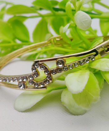 Gold-plated adjustable bracelet featuring a crystal-paved bowknot motif.