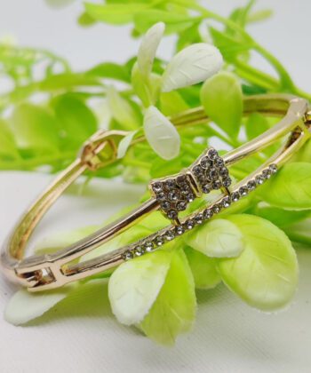 Gold-plated adjustable bracelet featuring a crystal-paved bowknot motif