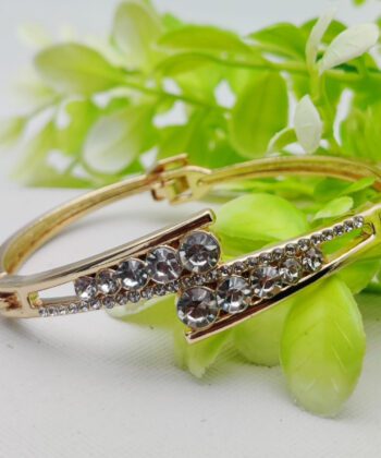 Gold-plated cross-over bracelet with a dense setting of brilliant crystals.