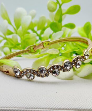 Gold-plated wavy bracelet with a series of round crystal embellishments.