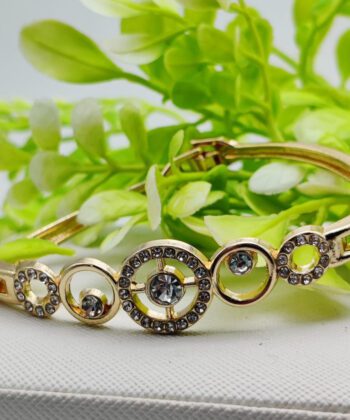 Gold-plated bracelet featuring concentric and interlocking crystal-studded circles.
