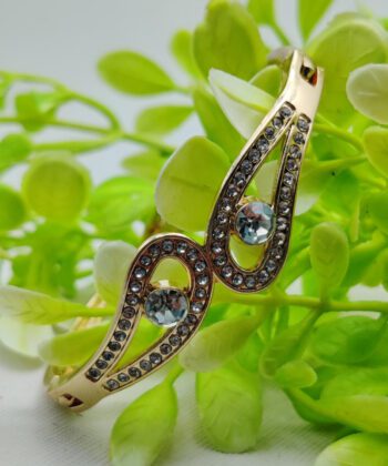 Gold-plated infinity wing bracelet with crystal accents and central stones.