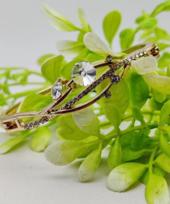 Gold-plated vine-shaped bracelet with leaf-like crystal embellishments.