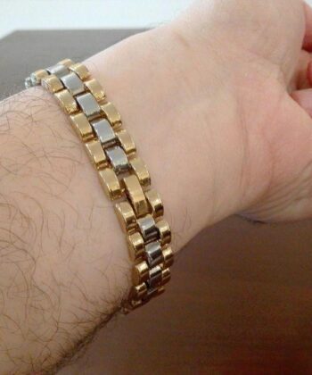 Men's two-tone gold and silver stainless steel presidential link bracelet on a wrist.